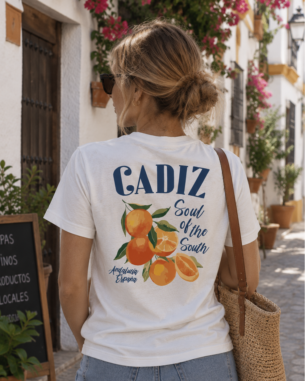 Modelo femenina con camiseta Cádiz blanca, diseño Naranjas Cádiz en la espalda