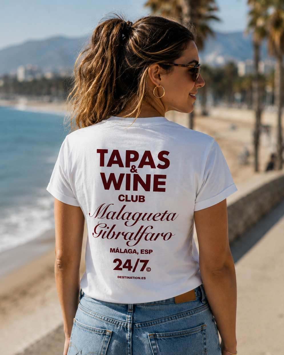 Modelo con camiseta blanca Tapas & Wine Club, diseño inspirado en La Malagueta y el Castillo de Gibralfaro – Destination.es