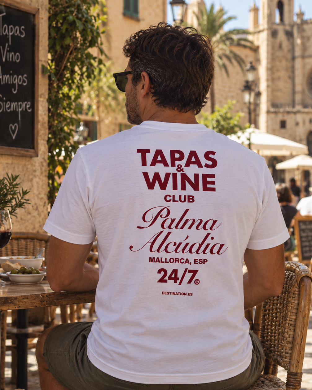 Modelo con Camiseta Tapas & Wine Club Mallorca blanca, diseño de texto granate – Destination.es