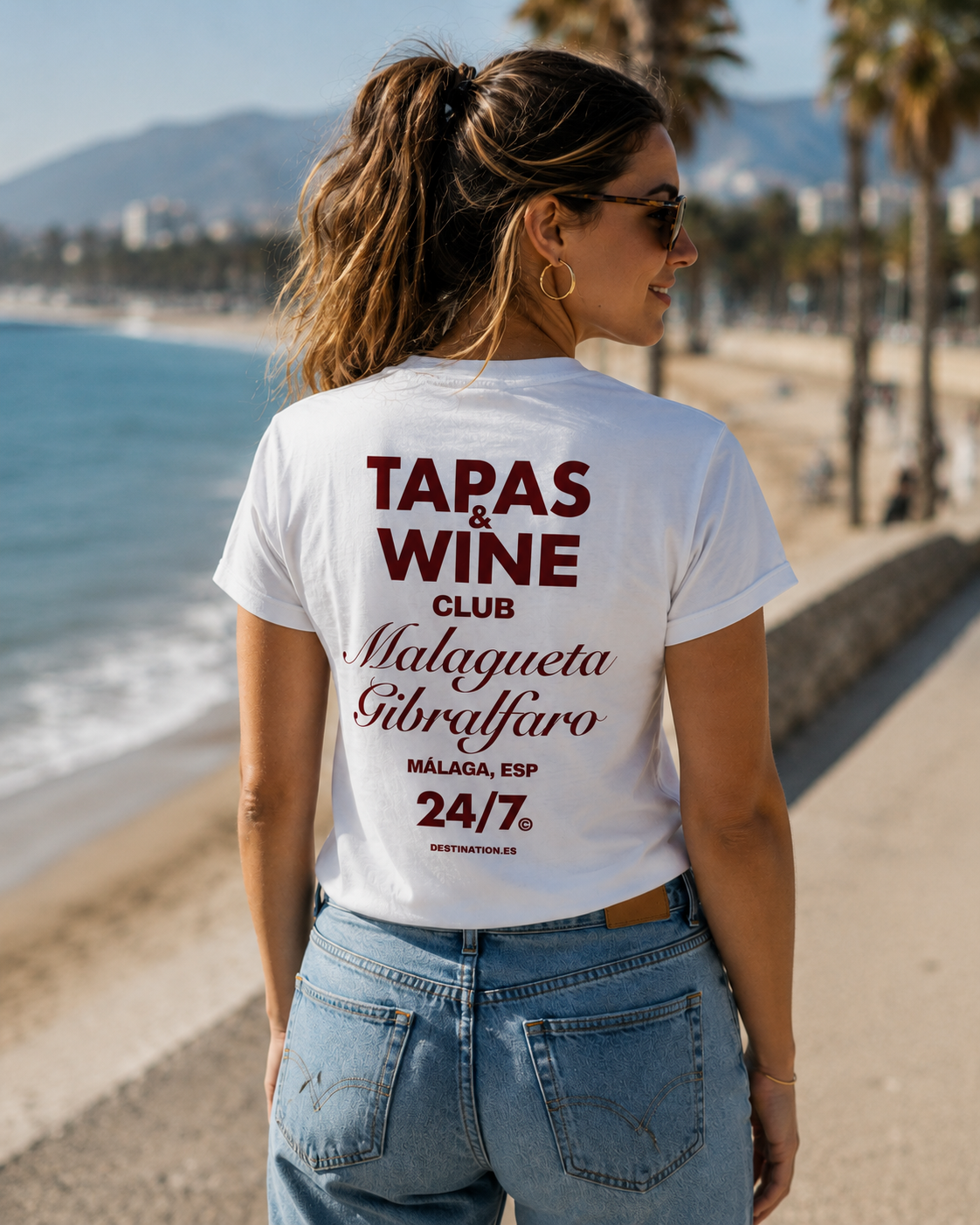 Modelo con camiseta blanca Tapas & Wine Club, diseño inspirado en La Malagueta y el Castillo de Gibralfaro – Destination.es